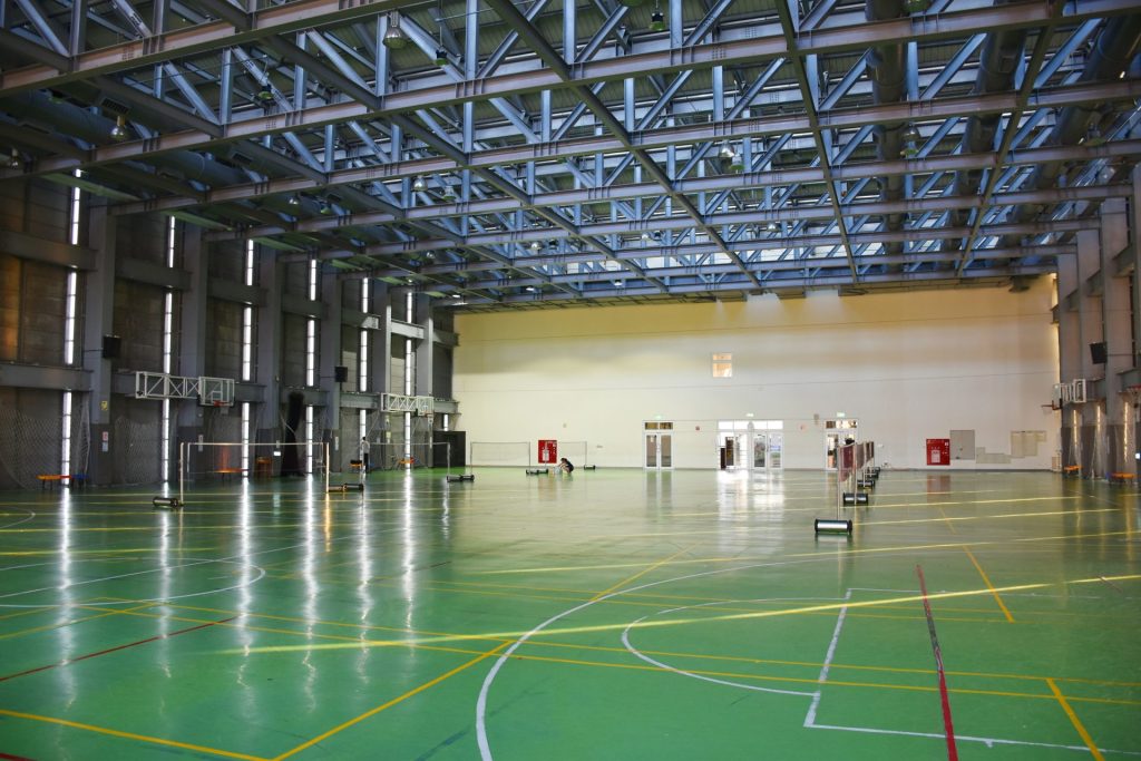 an indoor basketball court with green and yellow lines